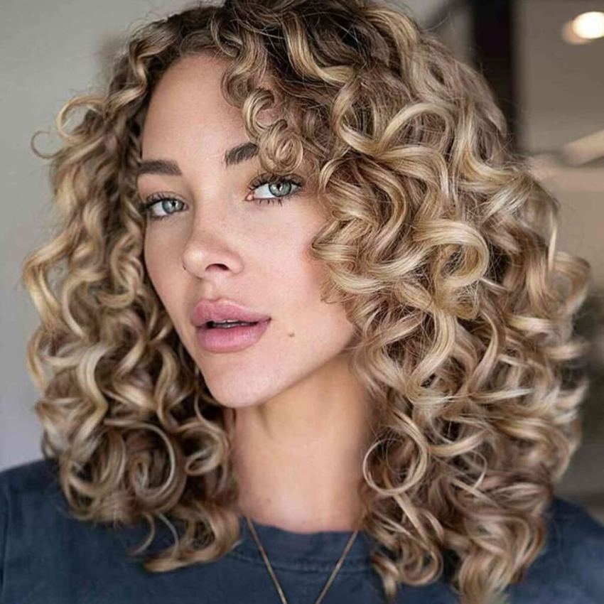 دختری با موهای رنگ بلوند شنی و فر حلقه ای درشت