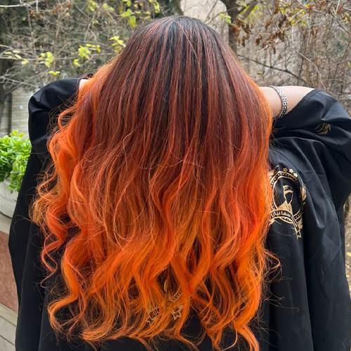 خانومی از پشت سر با موی بلند رنگ نارنجی پرتغالی